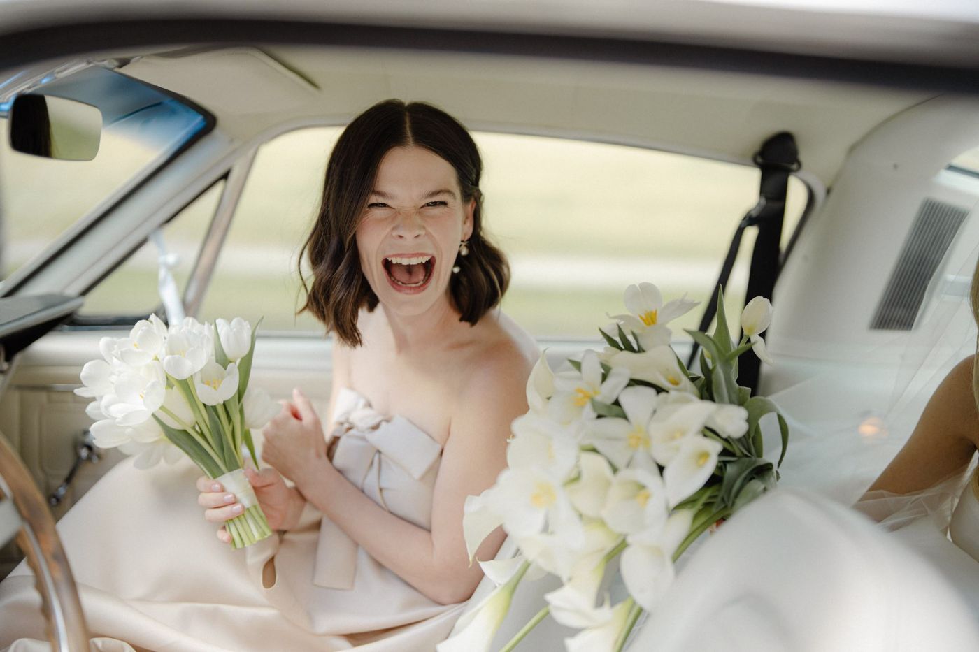 Bride laughing in the car on the way to her ceremony