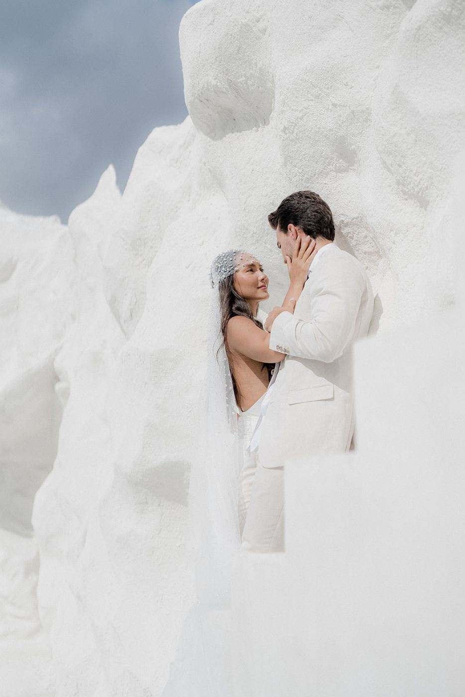 Couple embracing among white sculptural forms in Bali