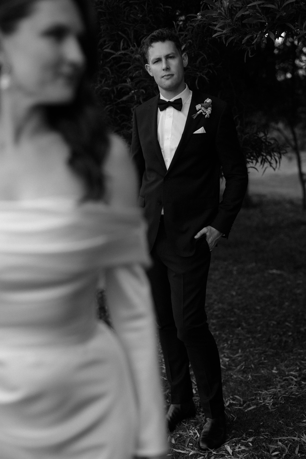 Groom waiting in soft focus behind his bride