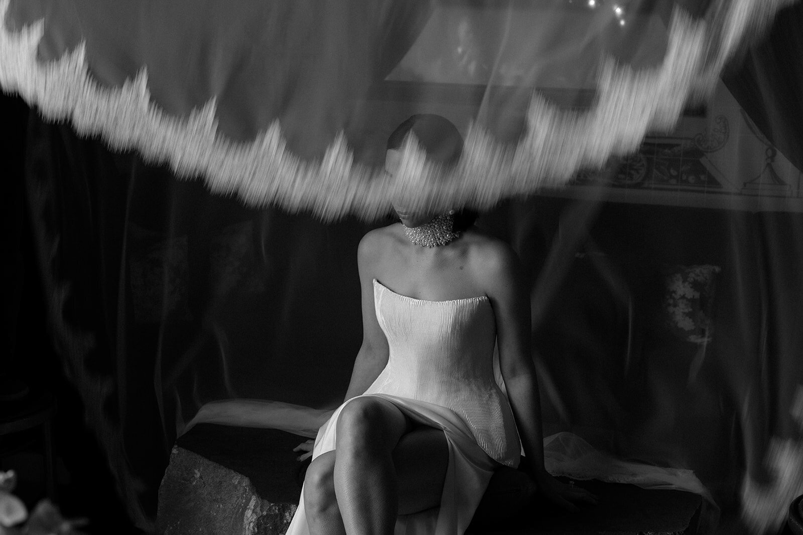 Bride seated beneath a lace-edged veil